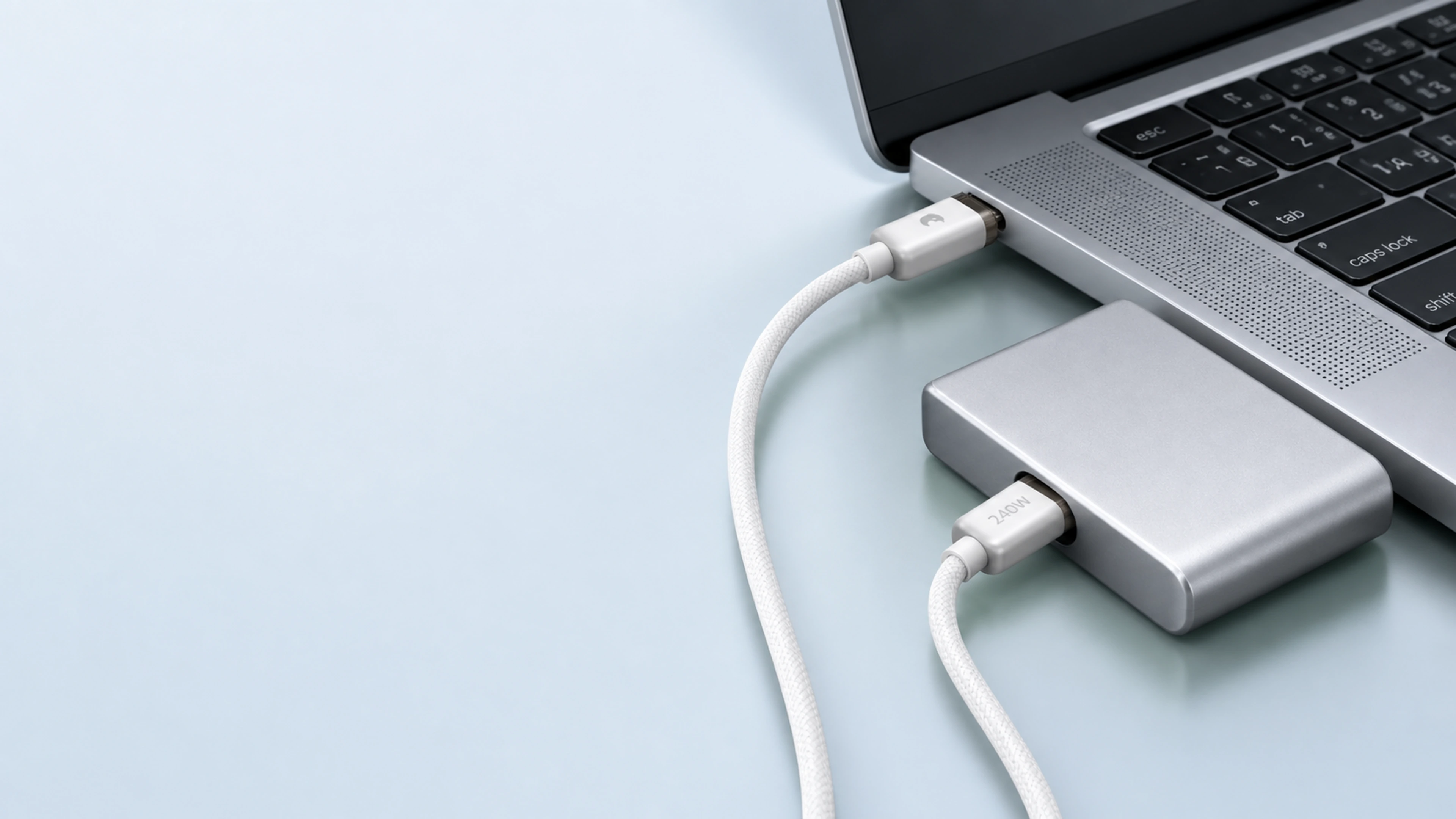 C1 圆编织线连接笔记本与便携存储,两枚银色 USB-C 端头清楚可见,多余线长自然延续至画外。